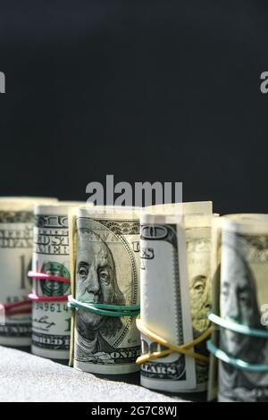 US-Dollar-Bundle-Nahaufnahme isoliert auf Dollar-Hintergrund. Papier Stückelungen von Dollar Cash-Rollen mit Gummibändern. Geschäftsbudget für Vermögen und p Stockfoto