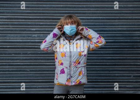 Frau mit Maske auf der Straße im Freien Stockfoto