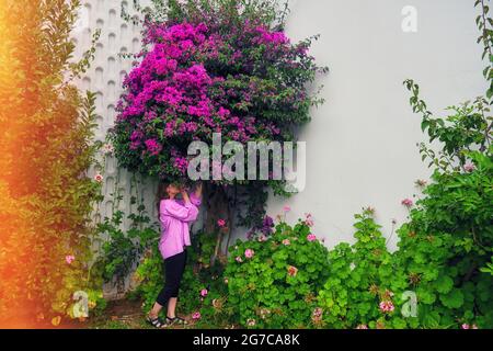 Die Frau neben dem Baum mit schönen violetten Blumen, kopieren Raum Stockfoto