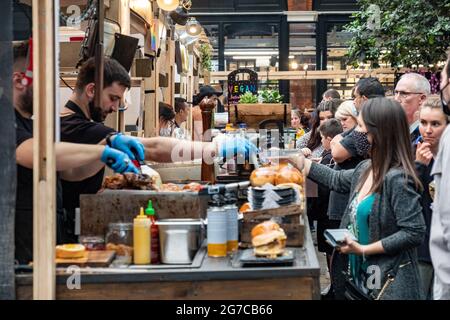 London - Juli 2021: Imbissstände auf dem Spitalfields Market. Ein beliebter Markt mit Lebensmitteln, Bars, Kunst und Kunsthandwerk Stockfoto