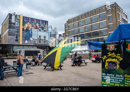 London - Juli 2021: Jamaikanischer Imbissstand in der Trumans Brewery in Shoreditch, einem lebhaften Sammlungsmarkt und Bars. Stockfoto