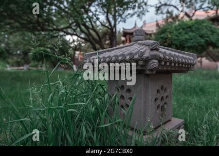 Eine traditionelle Steinlaterne im chinesischen Stil auf dem Grasland Stockfoto