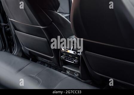 Innenraum eines Premium-Fahrzeugs. Der Rücksitz von Prestige Luxus modernen Auto. Schwarzes Leder und Bedienfeld für die Klimaanlage auf den Rücksitzen. Stockfoto