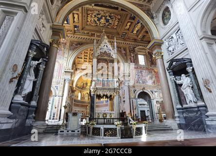 Perspektivische Ansicht der Apsis der römischen Kathedrale San Giovanni in Laterano, mit dem päpstlichen Altar, der Decke mit Einlegearbeiten und dem Gewölbe mit Fresken. Stockfoto