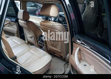 Modernes Luxusauto im Inneren. Bequeme beigefarbene Ledersitze und Bedienfeld für die Klimaanlage auf den Beifahrersitzen. Innenraum eines Premium-Fahrzeug autom Stockfoto