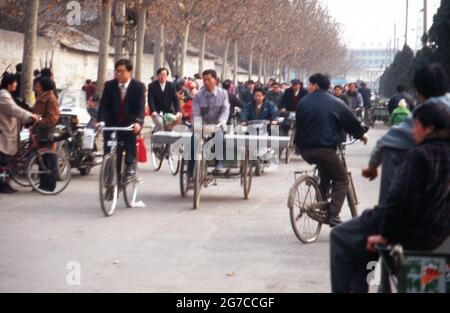 Fahrradfahrer bahnen sich ihren Weg durch die Menschen in der Stadt Xian, China 1998. Fahrradfahrer auf ihrem Weg durch die Menschenmassen in der Stadt Xian, China 1998. Stockfoto