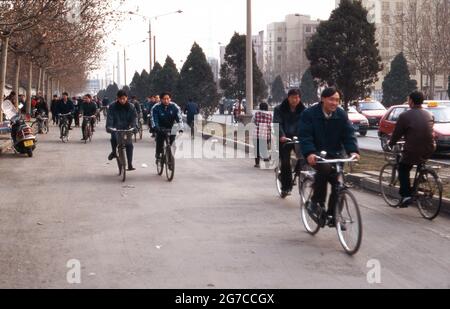 Fahrradfahrer bahnen sich ihren Weg durch die Menschen in der Stadt Xian, China 1998. Fahrradfahrer auf ihrem Weg durch die Menschenmassen in der Stadt Xian, China 1998. Stockfoto