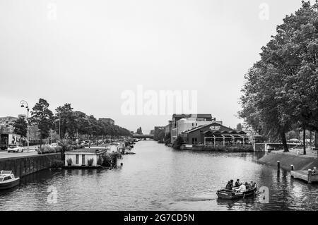 AMSTERDAM, NIEDERLANDE. 06. JUNI 2021. Schöner Blick auf einen Schiffskanal und Brücken. Schwarzweiß-Fotografie. Kleine Boote, Schiffe und Bargen Stockfoto