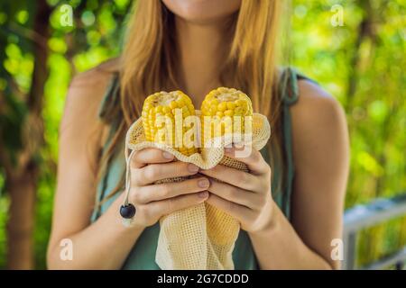 Mais in einer wiederverwendbaren Tasche in den Händen einer jungen Frau. Null-Abfall-Konzept Stockfoto