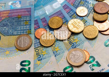 Münzen auf dem Hintergrund von zwanzig Euro-Banknoten, Nahaufnahme Stockfoto