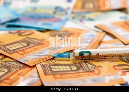 Nahaufnahme Spritze und Euro-Banknoten Scheine. Kosten für Gesundheit, Medizin, Drogenkonzept Stockfoto