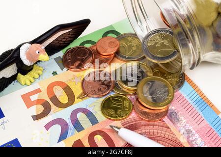 Ein Stillleben eines Geiers und Euro-Banknoten und -Münzen als Metapher für Geiergelder. Stockfoto