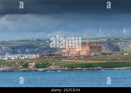 Ein Blick über die Fistral Bay von Pentire Point East bis zum legendären Headland Hotel in Newquay in Cornwall. Windpark St. Breock in weiter Ferne. Stockfoto