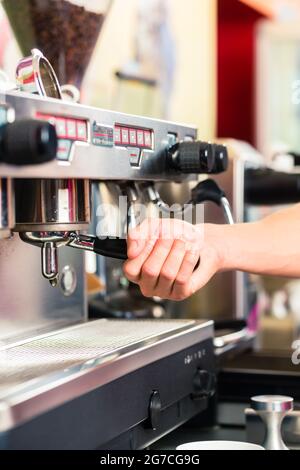 Barista Kaffee aus dem Automaten oder Einheit und Zubereitung von Espresso oder Cappuccino im Café oder shop Stockfoto