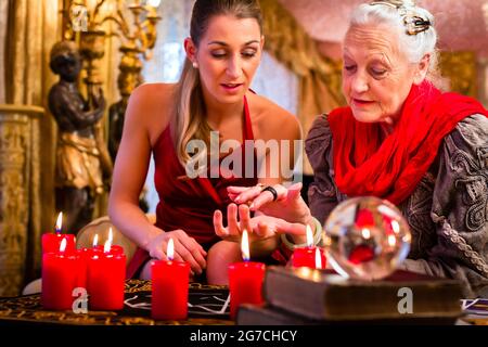 Weibliche Wahrsager oder esoterischen Oracle sieht in die Zukunft von Hand während einer Seance lesen, zu interpretieren und um Fragen zu beantworten Stockfoto