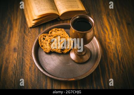 Das Sakrament der heiligen Kommunion - Brot, Wein und bibel auf Holztisch Stockfoto