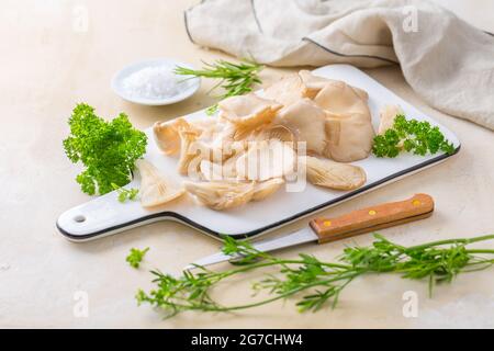 Bio Austernpilze mit Kräutern und Salz auf Schneidebrett Stockfoto