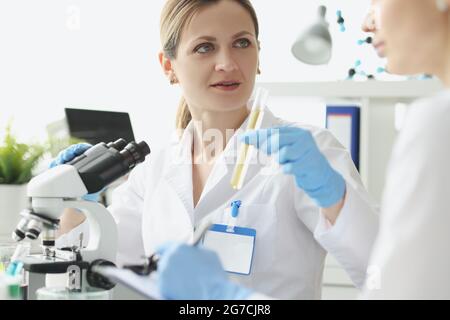 Zwei Forscher führen chemische Tests an Flüssigkeiten im Reagenzglas durch Stockfoto