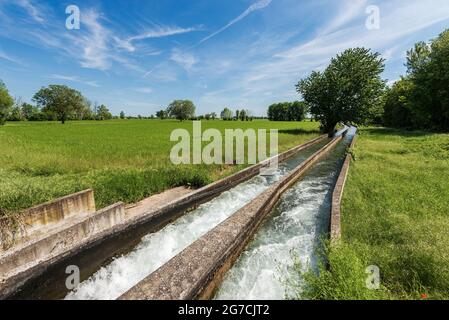 Zwei kleine Bewässerungskanäle aus Stahlbeton in der Padan-Ebene oder im Po-Tal (Pianura Padana, italienisch). Provinz Mantua, Italien, Südeuropa. Stockfoto