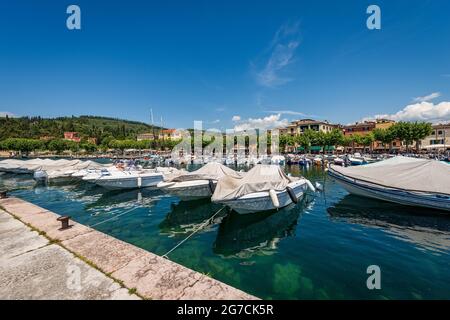 Hafen der kleinen Stadt Garda mit vielen Booten vertäut, Ferienort an der Küste des Gardasees (Lago di Garda). Verona, Venetien, Italien, Europa. Stockfoto