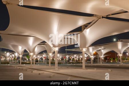 doha, katar - Mai 03 2021 : Parkplatz mit Sonnenschirm, um Schatten für Fahrzeuge während der Sommerperiode zu bieten. Nachtaufnahme Stockfoto