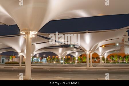 doha, katar - Mai 03 2021 : Parkplatz mit Sonnenschirm, um Schatten für Fahrzeuge während der Sommerperiode zu bieten. Nachtaufnahme Stockfoto