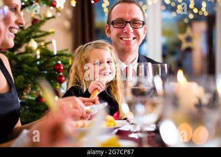 Eltern und Kinder Toasten mit Wein und Wasser bei Weihnachtsessen Stockfoto