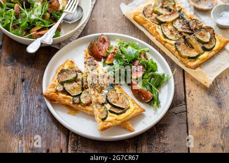Blätterteig-Torte mit karamellisierten Zucchini und Käse mit Beilage von Feigensalat Stockfoto