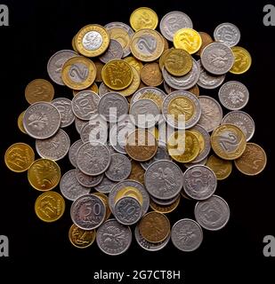 Stapel polnischer Münzen verschiedener Konfessionen, isoliert auf schwarzem Hintergrund. Stockfoto