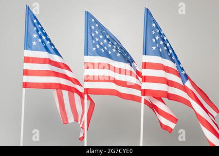 Rote und blaue amerikanische Flaggen mit Sternen und Streifen isoliert auf Grau Stockfoto