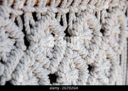 Nahaufnahme eines handgefertigten Makrammuster. Handgemachte stilvolle 100 Baumwolle Wand Macrame Dekoration. Natürliches modernes Dekorationskonzept im Innenraum. Stockfoto