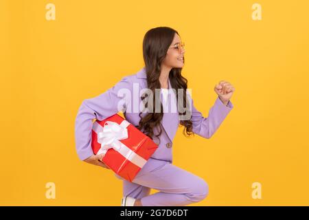 Shopper im Teenageralter. Beeil dich. stilvolle Teenager-Mädchen läuft mit Geschenkbox Stockfoto