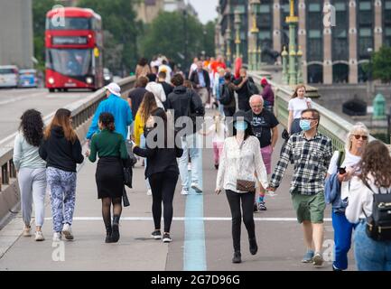 Fußgänger überqueren die Westminster Bridge, London, nachdem die Regierung die Aufhebung fast aller Beschränkungen des Coronavirus vom Juli 19 angekündigt hatte. Bilddatum: Dienstag, 13. Juli 2021. Stockfoto