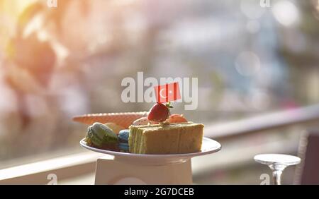 Gesunder Zucchini-Kuchen, Eis, Makronen und türkische Flagge auf einem weißen Teller. Das Frühstück in der Türkei war sehr lecker. Große Auswahl an türkischen Deligh Stockfoto
