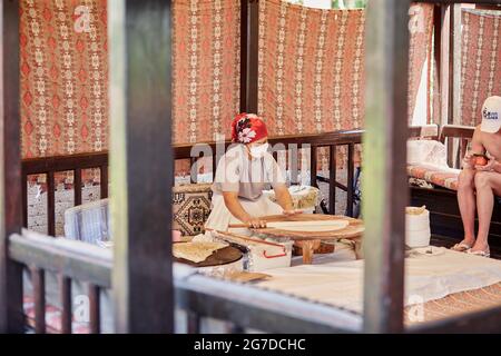 Kemer, Türkei - 25. Mai 2021: Frau bereitet im Freien nationales türkisches Fladenbrot zu. Teigvorbereitung. Türkische kulinarische Traditionen in der Küche. High qu Stockfoto