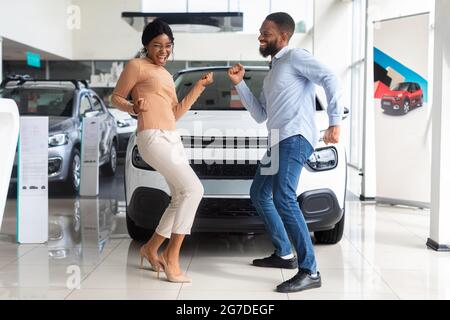 Aufgeregt Afroamerikanischen Ehegatten Tanzen In Händlerbüro Nach Dem Kauf Eines Neuen Autos Stockfoto