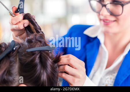 Weibliche Coiffeur Teilen Frauen Haare in Abschnitten mit Clips im shop Stockfoto