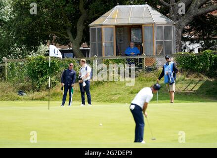 Ein Bewohner beobachtet den englischen Justin Rose während des Trainingstages im Royal St. George's Golf Club in Sandwich, Kent, auf dem 4. Green. Bilddatum: Dienstag, 13. Juli 2021. Stockfoto