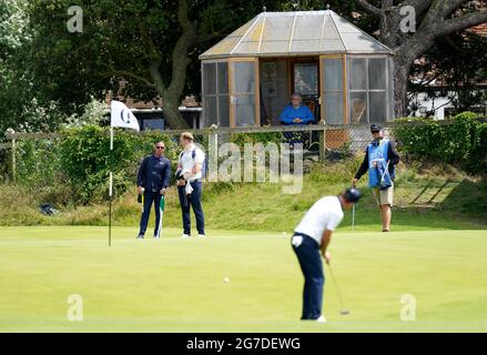 Ein Bewohner beobachtet den englischen Justin Rose während des Trainingstages im Royal St. George's Golf Club in Sandwich, Kent, auf dem 4. Green. Bilddatum: Dienstag, 13. Juli 2021. Stockfoto