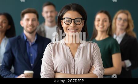 Glückliche weibliche Geschäftsführerin, die vor dem Team steht Stockfoto