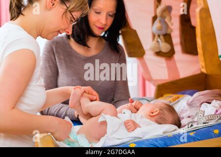 Hebamme, neugeborenes Baby auf postnatale Pflege in der Praxis zu prüfen Stockfoto