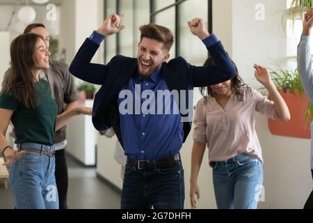 Fröhliches Büroteam, das Spaß auf der Party hat und gute Ergebnisse feiert Stockfoto