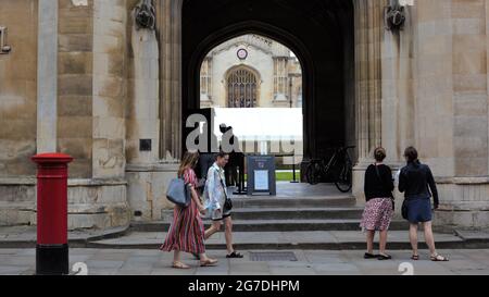 Straßenszene mit mehreren Personen, die durch einen Archway schauen und Eingang zum Corpus Christi College, Cambridge University, Großbritannien Stockfoto