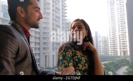Nahaufnahme eines südasiatischen Paares mit dem sprechenden Mann und der Frau, die ihn aufgeregt anstarrte Stockfoto