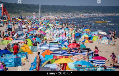 Zinnowitz, Deutschland. Juli 2021. Strandgänger haben sich am Strand der Ostsee bei Temperaturen von fast 30 Grad versammelt. Viele Touristen genießen Sonne, Sand, Wellen und Meer am Strand auf der Insel Usedom. Quelle: Stefan Sauer/dpa/Alamy Live News Stockfoto