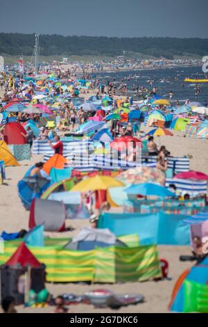 Zinnowitz, Deutschland. Juli 2021. Strandgänger haben sich am Strand der Ostsee bei Temperaturen von fast 30 Grad versammelt. Viele Touristen genießen Sonne, Sand, Wellen und Meer am Strand auf der Insel Usedom. Quelle: Stefan Sauer/dpa/Alamy Live News Stockfoto