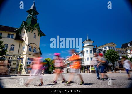 Zinnowitz, Deutschland. Juli 2021. Strandgänger auf dem Weg zur Ostsee. Viele Touristen genießen Sonne, Sand, Wellen und Meer am Strand auf der Insel Usedom. (Langzeitbelichtung) Quelle: Stefan Sauer/dpa/Alamy Live News Stockfoto