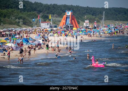 Zinnowitz, Deutschland. Juli 2021. Strandgänger haben sich am Strand der Ostsee bei Temperaturen von fast 30 Grad versammelt. Viele Touristen genießen Sonne, Sand, Wellen und Meer am Strand auf der Insel Usedom. Quelle: Stefan Sauer/dpa/ZB/dpa/Alamy Live News Stockfoto