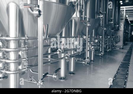 Private Mikrobrauerei. Moderne Bieranlage mit Braukesseln, Röhren und Tanks aus Edelstahl Stockfoto