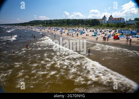 Zinnowitz, Deutschland. Juli 2021. Strandbesucher haben sich bei Temperaturen von fast 30 Grad am Strand an der Ostsee versammelt. Viele Touristen genießen Sonne, Sand, Wellen und Meer am Strand auf der Insel Usedom. (Langzeitbelichtung) Quelle: Stefan Sauer/dpa/Alamy Live News Stockfoto